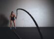 Female athlete performing intense battle ropes exercise at Anthony Bevington Fitness.
